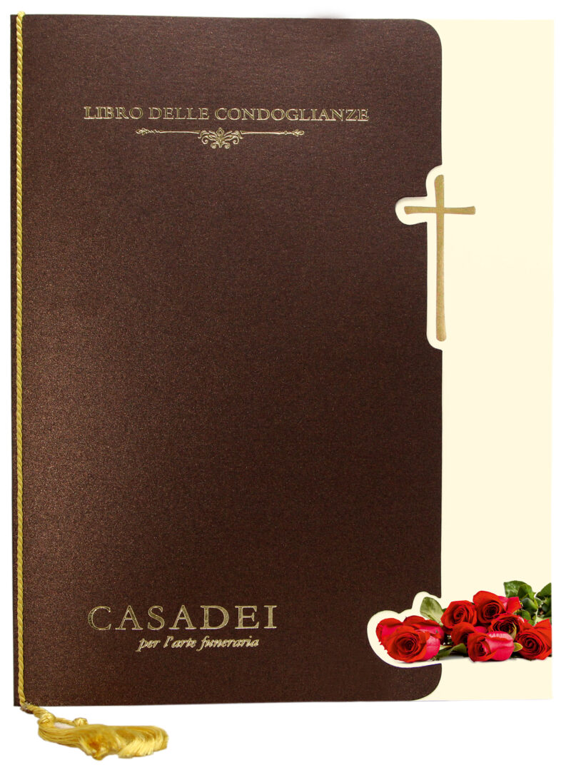 Libro delle condoglianze con copertina sagomata immagine Croce e rose in cartone bronzo, interno composto da una pagina "In memoria" e otto pagine per le firme in carta avorio, rilegato con cordoncino e nappa. 21x29,7 cm.
